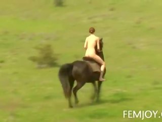 Bystiga rödhårig abby rider en häst naken